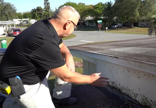Michael Vecchione checking a damaged roof edge up close