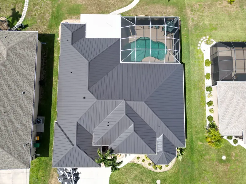 Top-down view of a charcoal metal roof and pool cage